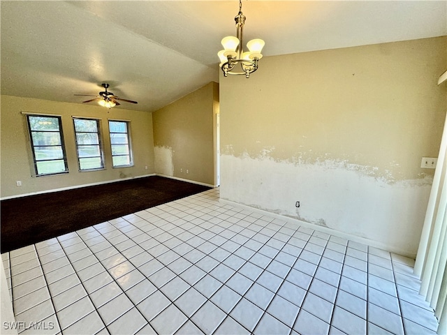 spare room with ceiling fan with notable chandelier, light tile patterned floors, and lofted ceiling