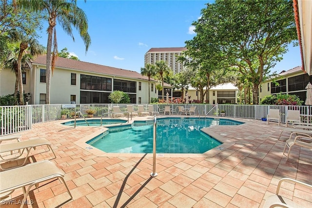 view of pool with a community hot tub and a patio