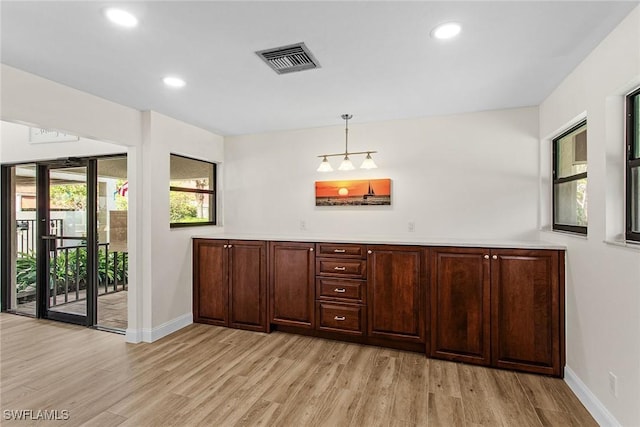 bar featuring decorative light fixtures and light wood-type flooring