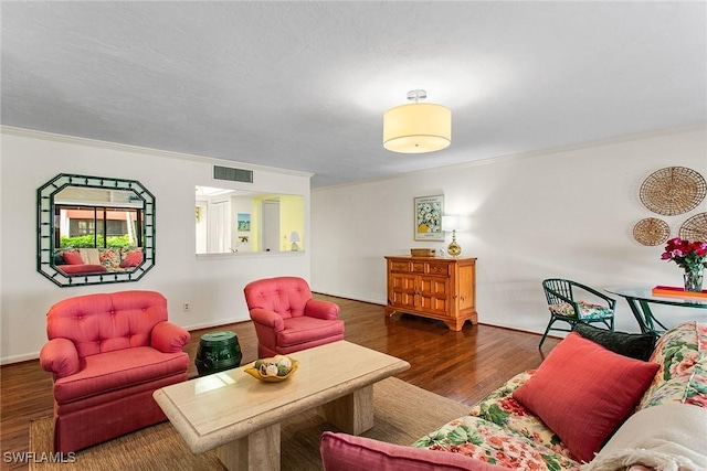 living room featuring dark wood-type flooring and crown molding