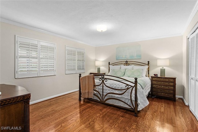 bedroom with a closet, crown molding, and hardwood / wood-style floors