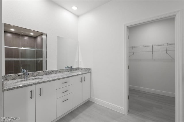 bathroom featuring vanity, a shower with shower door, and hardwood / wood-style flooring