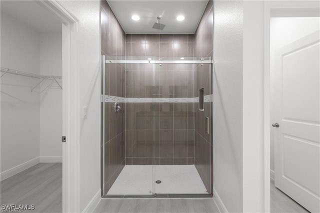 bathroom with hardwood / wood-style flooring and an enclosed shower