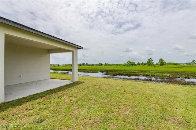 view of yard with a patio and a water view