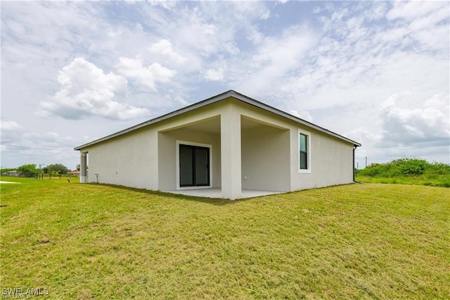 back of property with a patio area and a yard