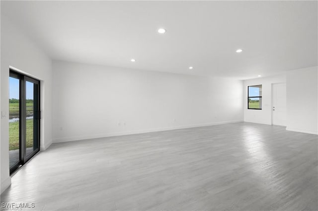 spare room with plenty of natural light and light hardwood / wood-style flooring