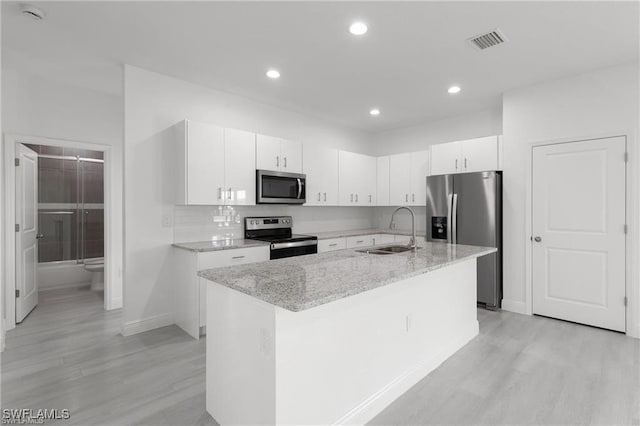 kitchen featuring white cabinetry, a kitchen island with sink, sink, and stainless steel appliances