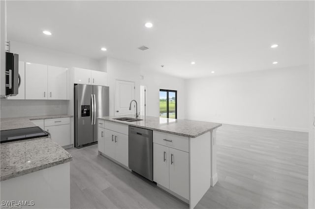 kitchen with a center island with sink, white cabinetry, and stainless steel appliances