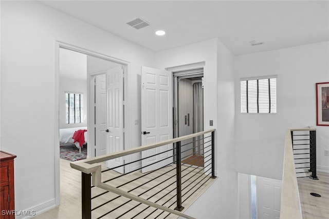 hallway with plenty of natural light and light hardwood / wood-style floors