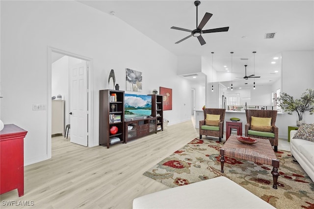 living room featuring ceiling fan and light hardwood / wood-style floors