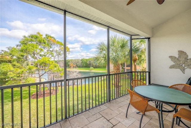 sunroom featuring a water view, ceiling fan, and lofted ceiling