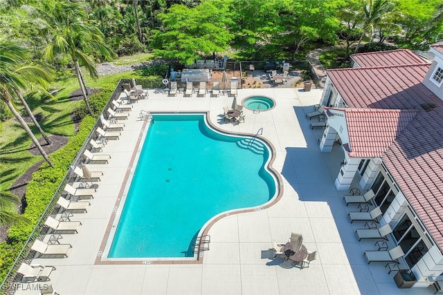 view of swimming pool with a hot tub and a patio