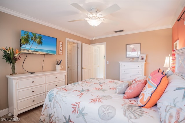 bedroom featuring hardwood / wood-style flooring, ceiling fan, and crown molding