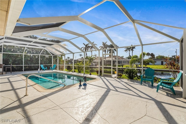 view of swimming pool featuring a patio area and a lanai