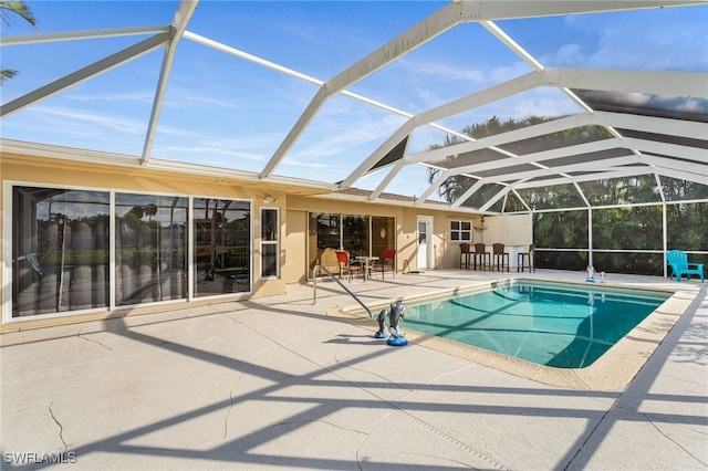 view of swimming pool featuring glass enclosure and a patio area