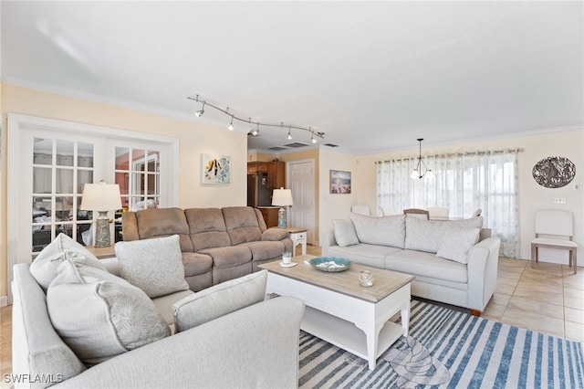 tiled living room with french doors, a notable chandelier, and ornamental molding