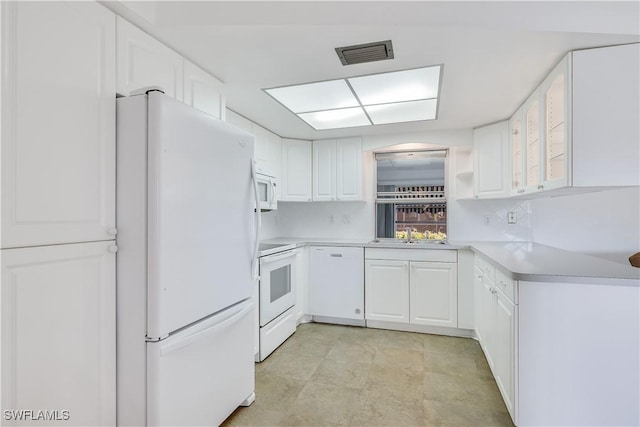 kitchen featuring sink, white cabinets, and white appliances