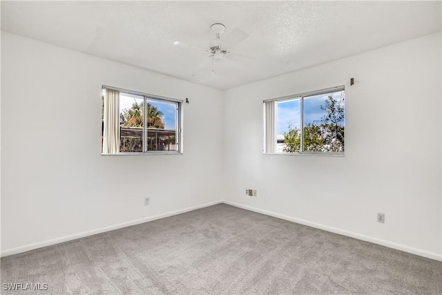 carpeted spare room featuring a textured ceiling and ceiling fan