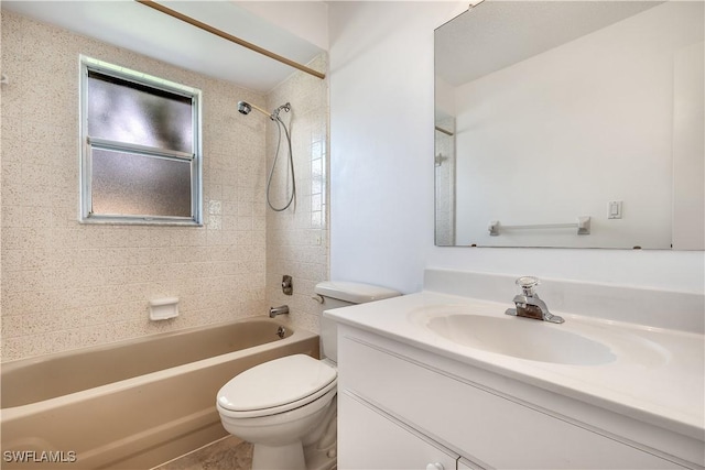 full bathroom featuring vanity, tiled shower / bath, and toilet