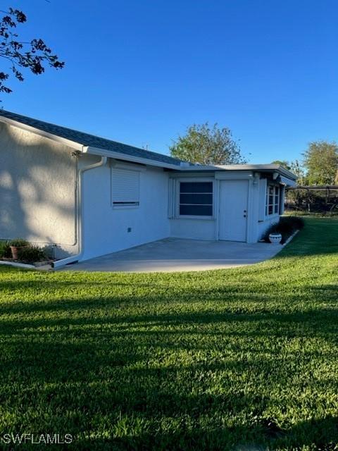 back of property featuring a yard and a patio area