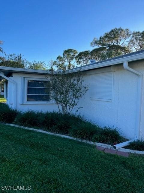 view of side of home with a yard