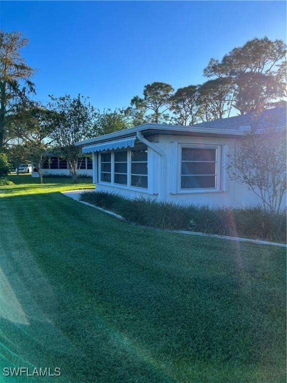 view of side of home with a yard