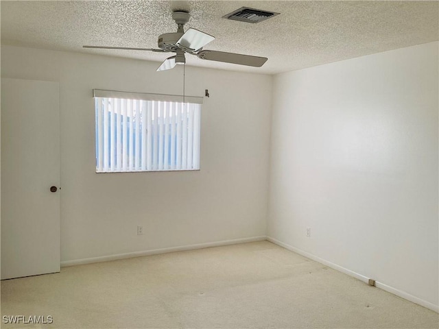 carpeted spare room with ceiling fan and a textured ceiling