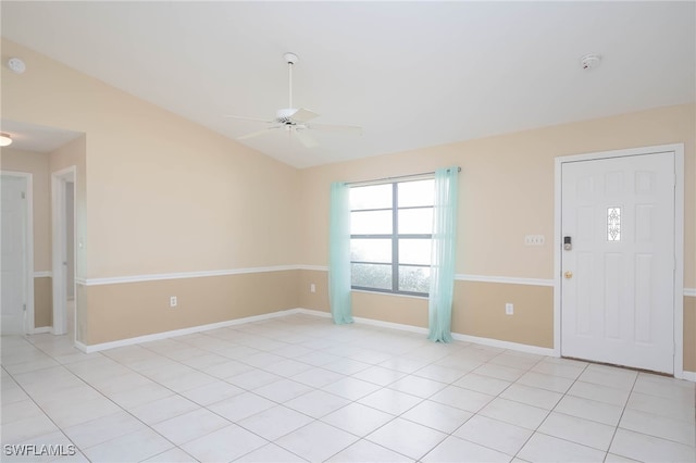 interior space featuring ceiling fan, light tile patterned floors, and vaulted ceiling