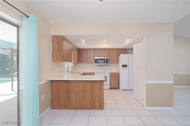 kitchen featuring kitchen peninsula, a raised ceiling, light tile patterned floors, range, and white fridge with ice dispenser