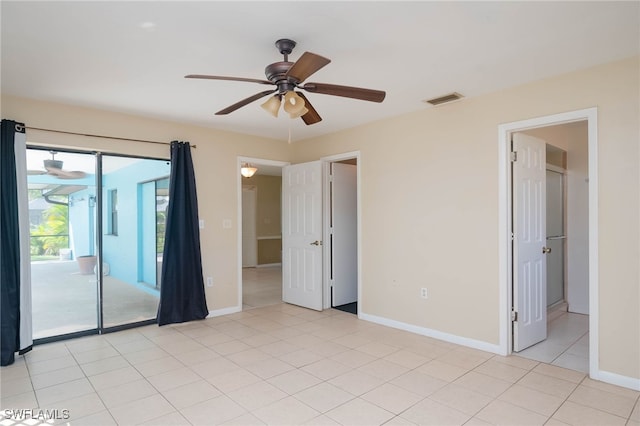 empty room with ceiling fan and light tile patterned floors