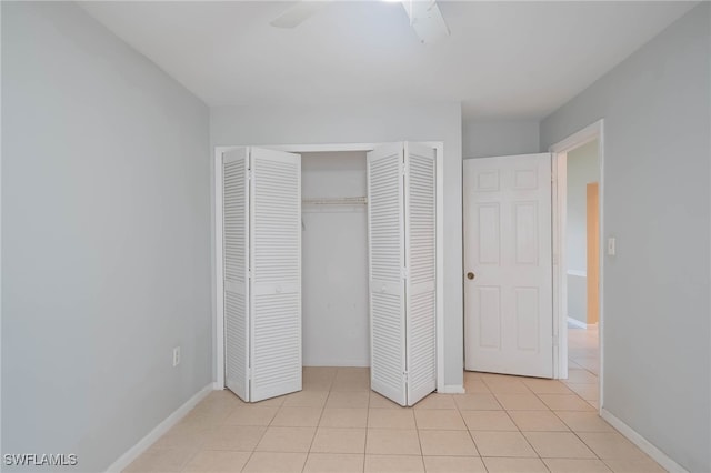 unfurnished bedroom featuring ceiling fan, light tile patterned floors, and a closet