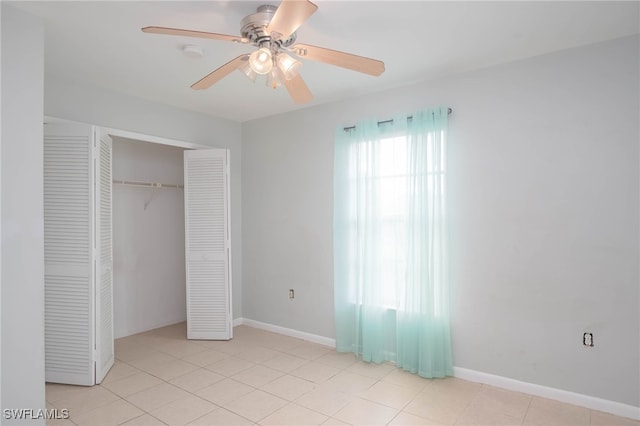 unfurnished bedroom featuring ceiling fan, light tile patterned floors, and a closet