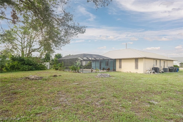 view of yard with central AC unit and a lanai