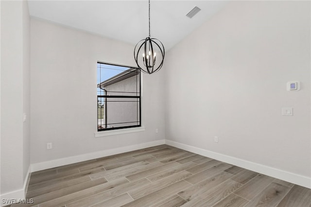 unfurnished dining area with a chandelier and light wood-type flooring