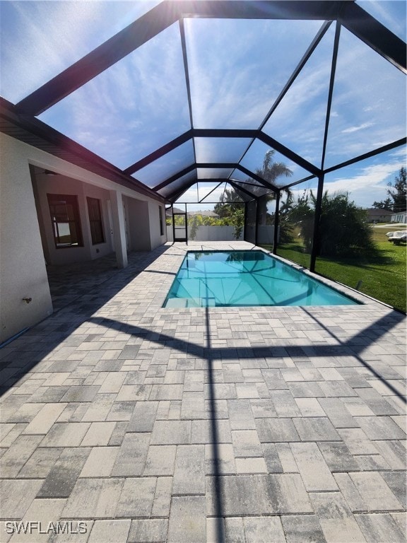 view of pool featuring glass enclosure and a patio