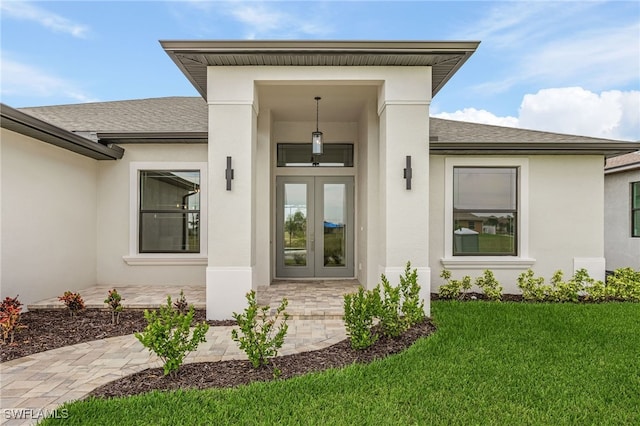 doorway to property featuring a lawn and french doors