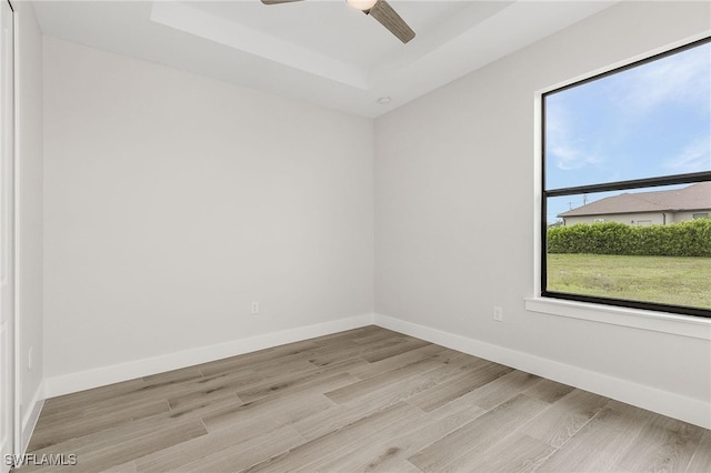 spare room with ceiling fan, plenty of natural light, and light hardwood / wood-style floors