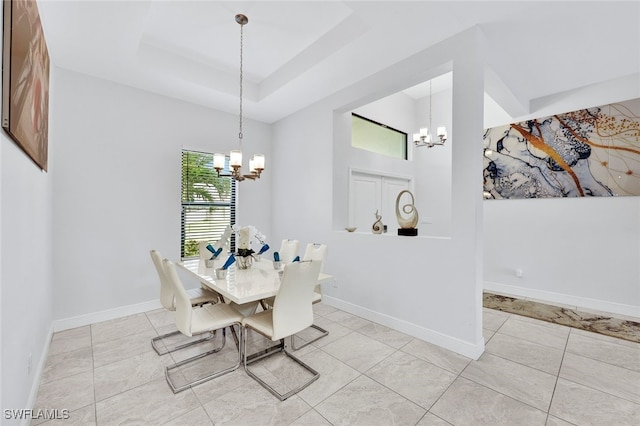 tiled dining area with a tray ceiling and an inviting chandelier