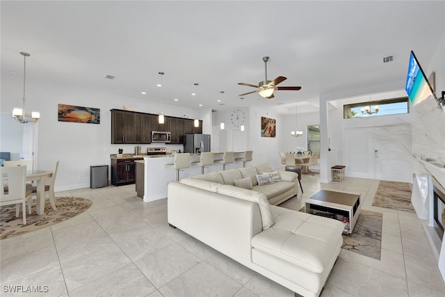 living room featuring ceiling fan with notable chandelier