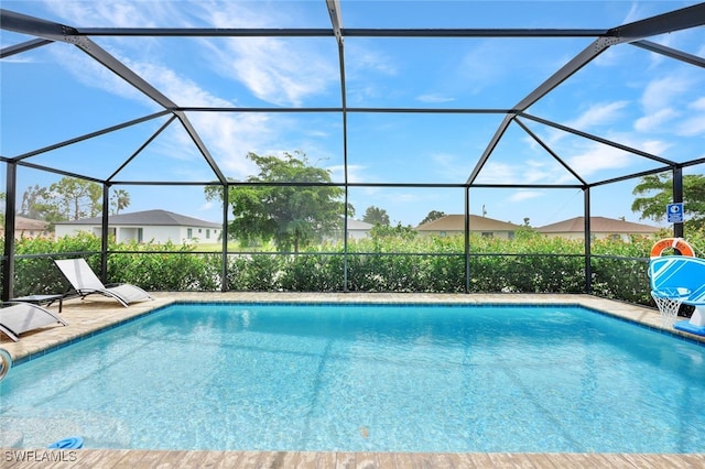 view of swimming pool with a patio area and a lanai