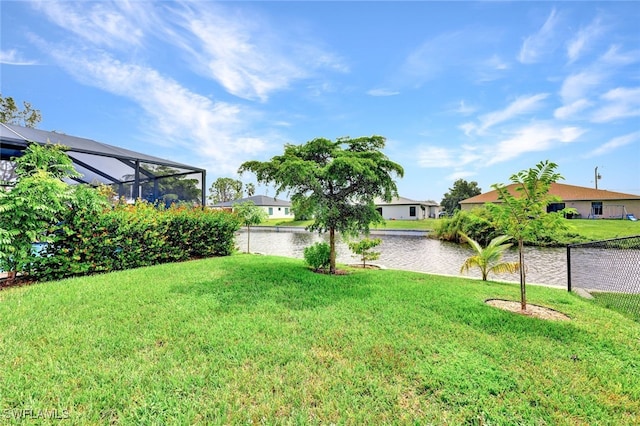 view of yard featuring a water view and glass enclosure