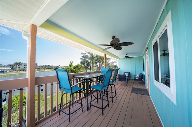 wooden terrace featuring a water view and ceiling fan