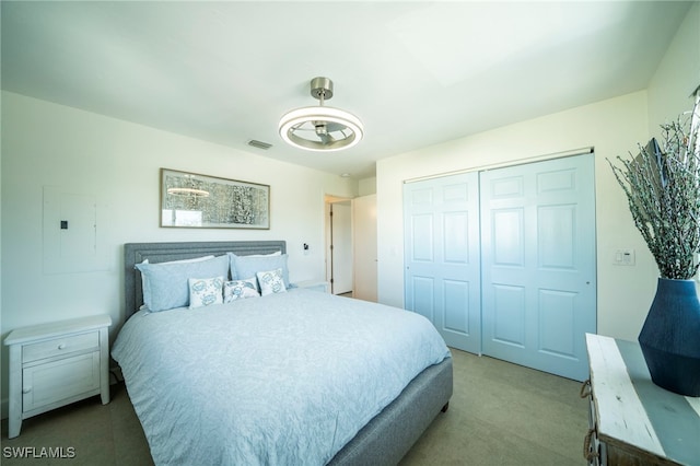 bedroom with carpet floors, electric panel, and a closet