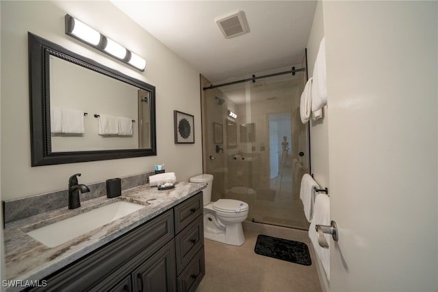 bathroom with vanity, a shower with shower door, and toilet