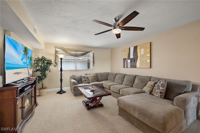 living room featuring a textured ceiling, light colored carpet, and ceiling fan