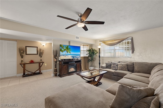 tiled living room featuring ceiling fan and a textured ceiling