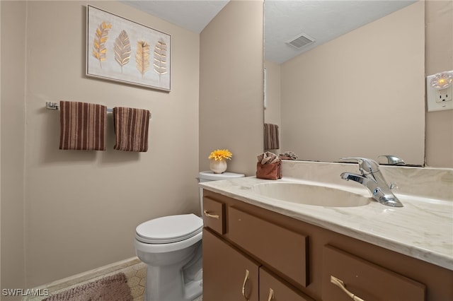 bathroom featuring tile patterned flooring, vanity, and toilet