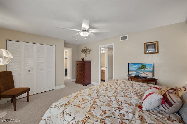 bedroom featuring ceiling fan, a closet, ensuite bathroom, and light colored carpet