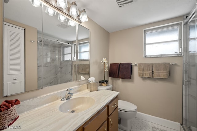 bathroom featuring tile patterned flooring, vanity, toilet, and walk in shower