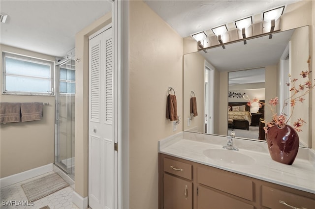 bathroom with a shower with door, vanity, and tile patterned flooring